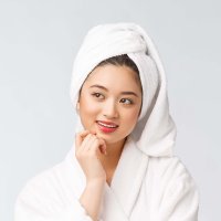Spa skincare beauty Asian woman drying hair with towel on head after shower treatment. Beautiful multiracial young girl touching soft skin.